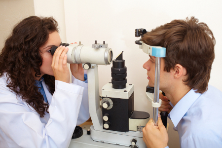 Optometrist checking the eyes of a teenager